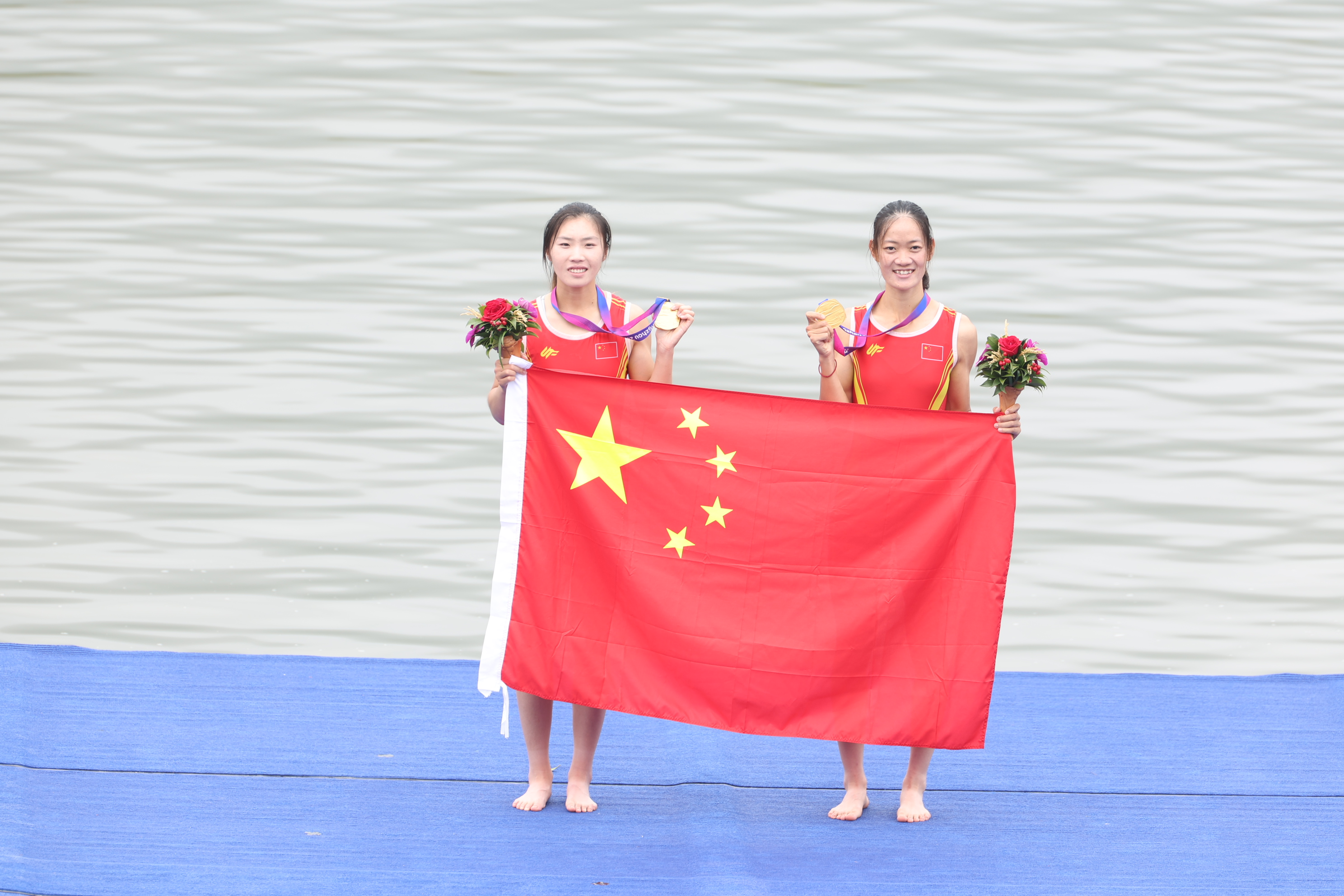 9月24日，邹佳琪（左）与邱秀萍在杭州亚运会赛艇女子轻量级双人双桨项目上夺得金牌。图为她们在颁奖典礼上。 人民网记者 李乃妍摄
